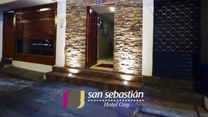 L’entrée d’un hôtel avec une façade en pierre, une porte en bois et une enseigne indiquant « San Sebastián Hotel Gay ».