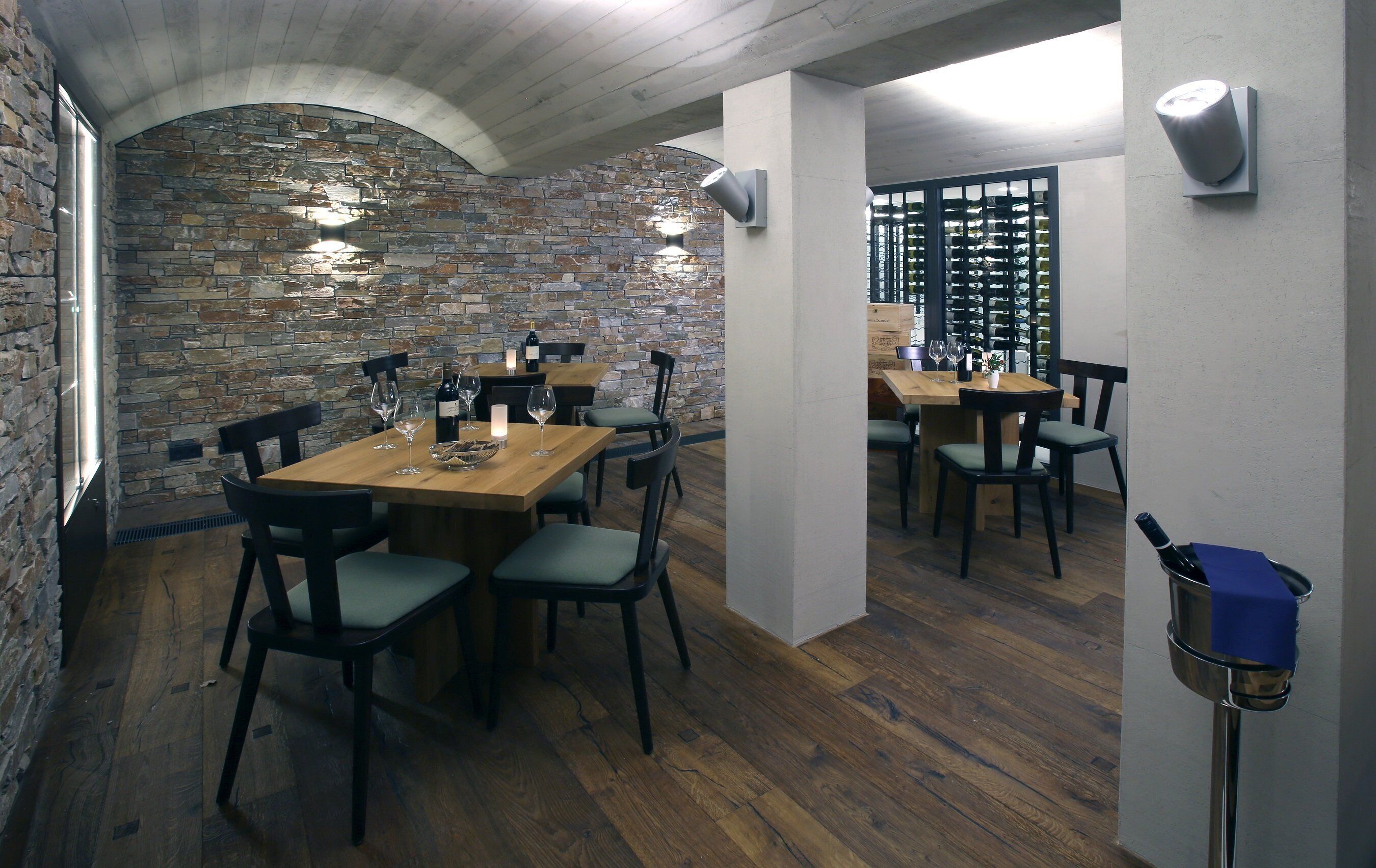 Un restaurante con paredes de piedra, mesas y sillas de madera.