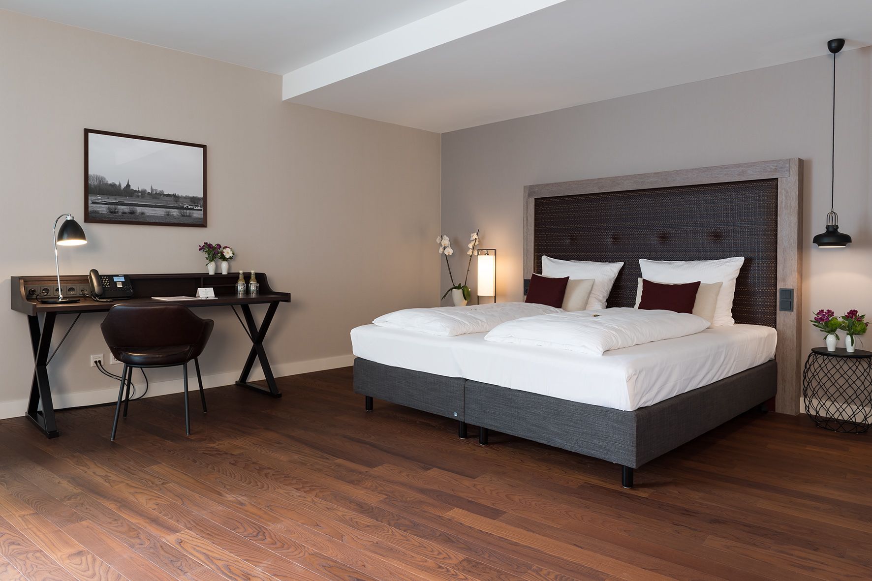 Un dormitorio moderno con una cama grande, un escritorio y una silla.