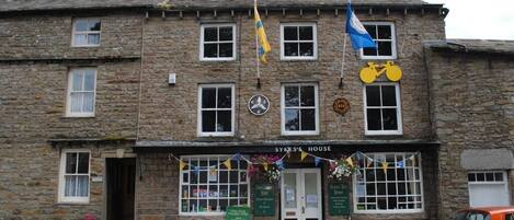 A stone building with a sign reading 'SYKES'S HOUSE' and a bicycle symbol.