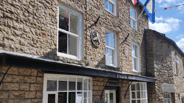 A stone building with a sign for "Sykes's House" offering bed and breakfast. - Sykes's House (Leyburn)