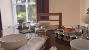 A dining table set with bowls, a cup, a spoon, and a jar of honey. - Sykes's House (Leyburn)