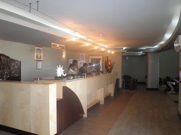 Zona de recepción con mostrador, certificados enmarcados y señalización.