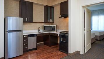 A compact kitchen with a refrigerator, microwave, dishwasher, and oven.