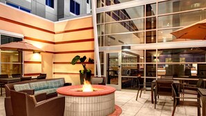 A spacious outdoor seating area with a fire pit, wicker furniture, and a large umbrella. - Residence Inn by Marriott Philadelphia Airport (Philadelphia)