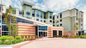A modern hotel with a central entrance, multiple floors, and a landscaped courtyard. - Residence Inn by Marriott Philadelphia Airport (Philadelphia)