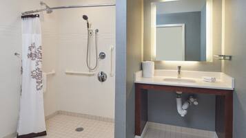 Un baño con ducha, inodoro, lavabo y espejo.