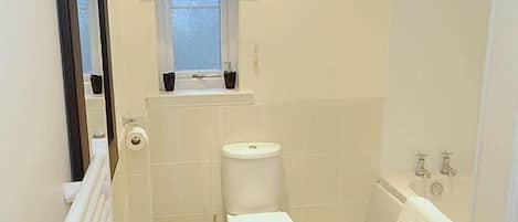 A small, clean bathroom with a white sink, toilet, and bathtub.