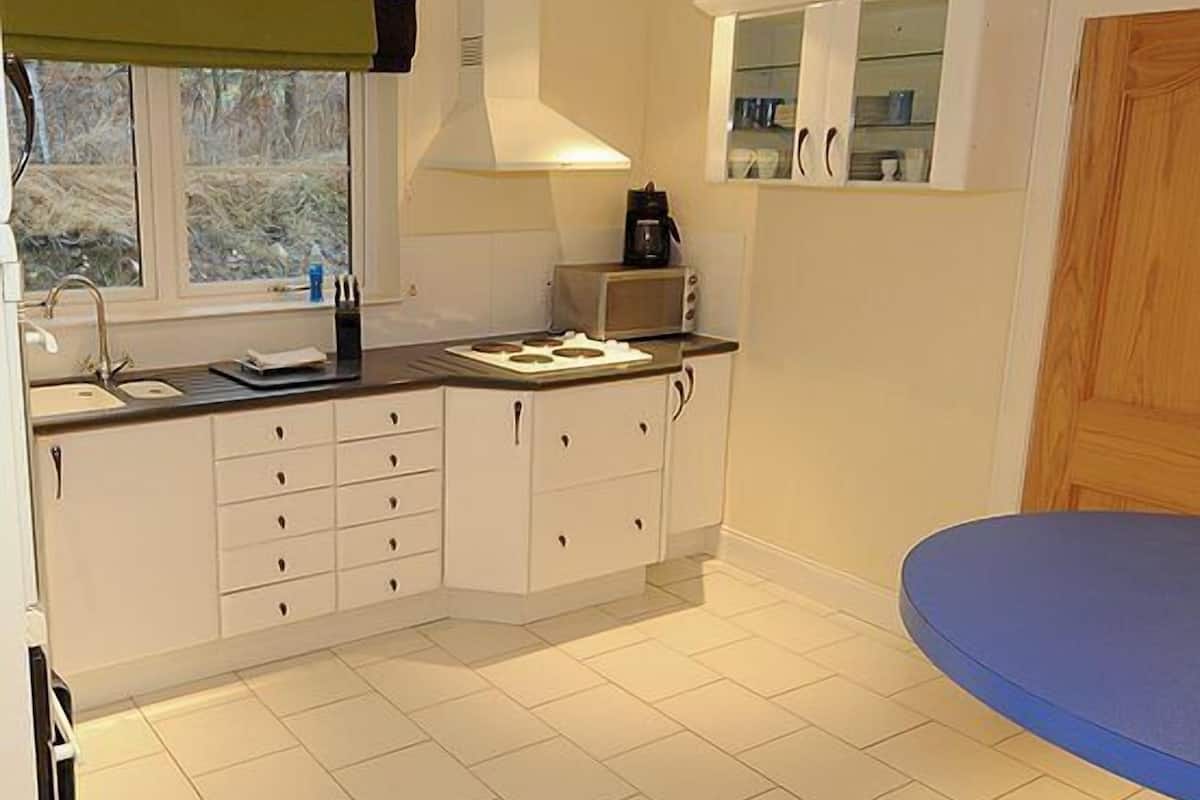 A compact kitchen with white cabinets, a microwave, and a coffee maker.