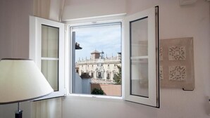 Una habitación con un ventanal que ofrece vistas a un edificio histórico.