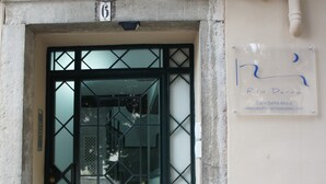 Una puerta con un diseño geométrico, el número '6' encima y un cartel con una URL en la pared a la derecha.