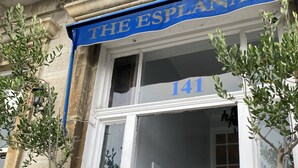A building facade with a blue awning labeled "THE ESPILANADE" and the number "141" above the entrance. - The Esplanade (Weymouth)
