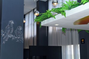 Un interior moderno con una planta colgante, iluminación colgante y un símbolo de Wi-Fi.