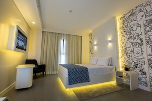 Un dormitorio moderno con cama, mesita de noche y una pared con un mural en blanco y negro.