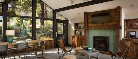 Un salón comedor amplio con chimenea, ventanas grandes y techo alto.