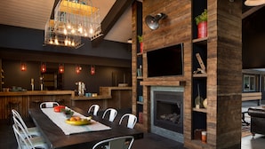 Een moderne keuken met een eethoek, houten details en een open haard.
