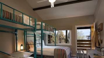Ein Schlafsaalzimmer mit Stockbetten, einem Schreibtisch und einem Stuhl. Ein Fenster bietet Blick ins Freie.