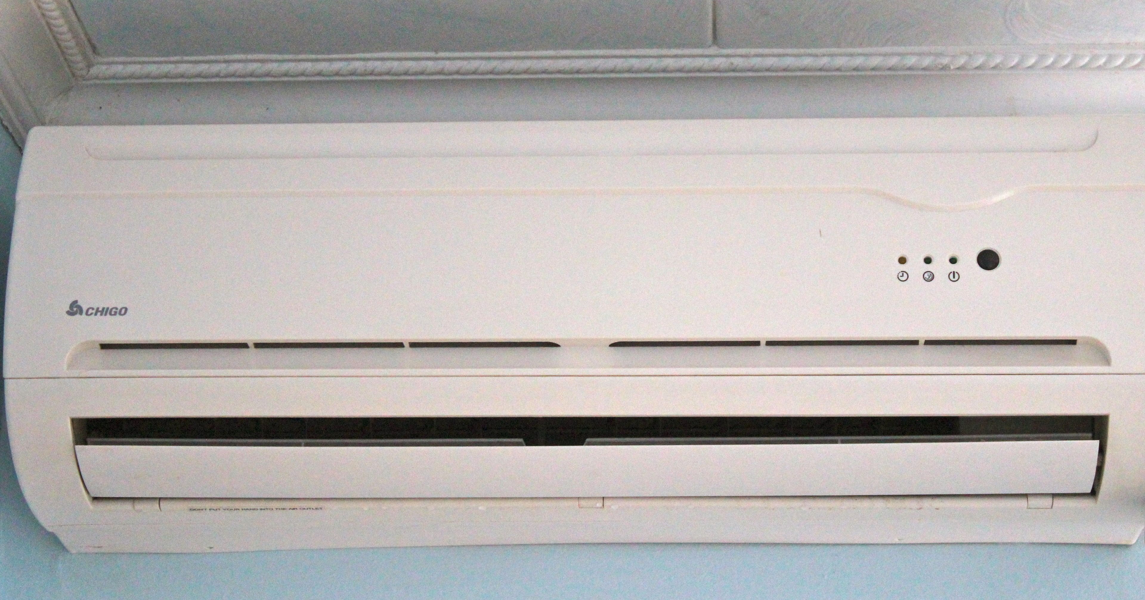A white Chigo air conditioner unit with a control panel, a power button, and a display.