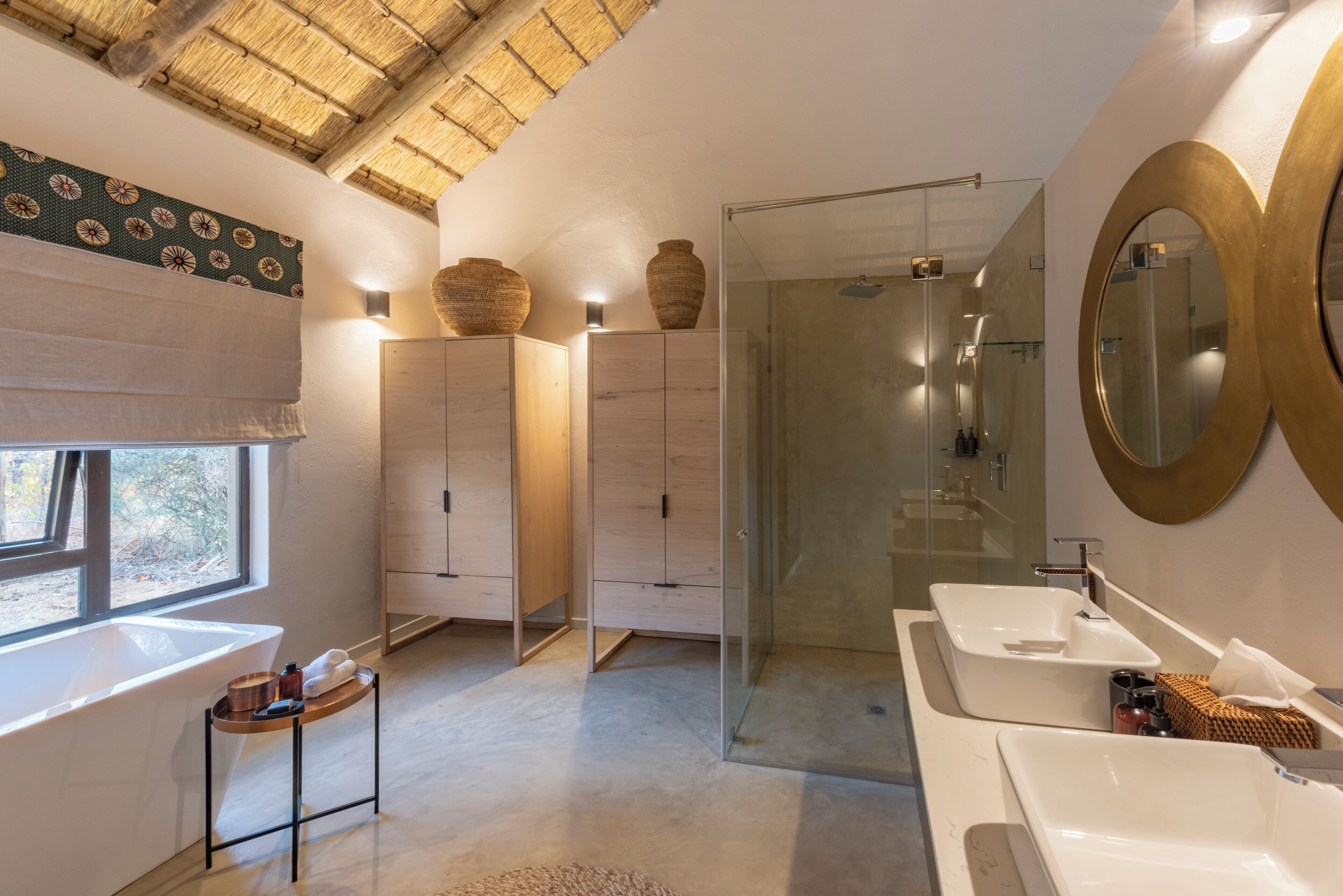 A modern bathroom with two sinks, a glass shower, and a large mirror.