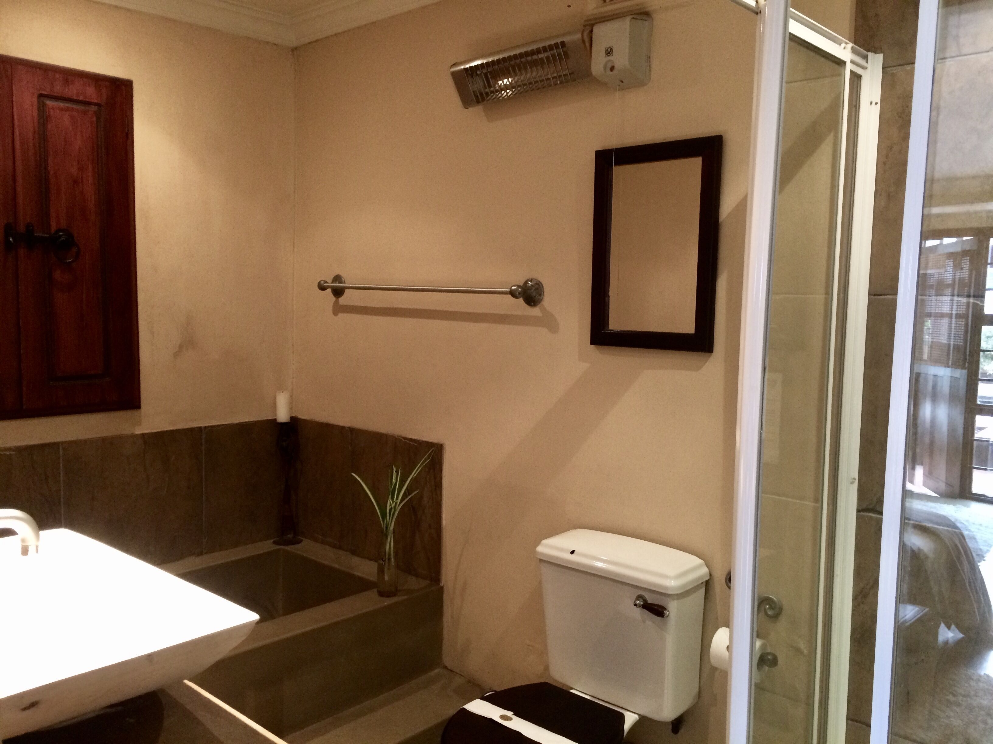 A bathroom with a white sink, a toilet, a shower, and a towel rack.
