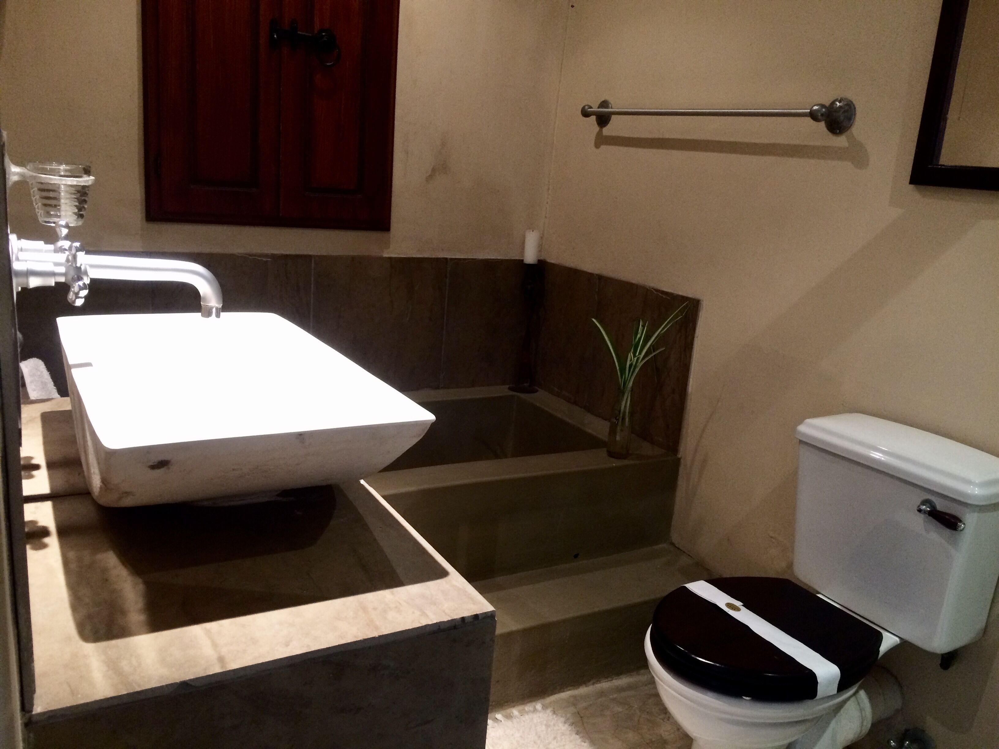 A bathroom with a white sink, a toilet, and a shower area.