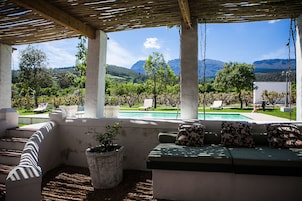 Una piscina al aire libre, sombrillas, sillones reclinables de piscina