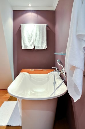 A bathroom with a white sink, a glass shelf, and two white towels hanging on the wall. - Tamboti Lodge (Tzaneen)