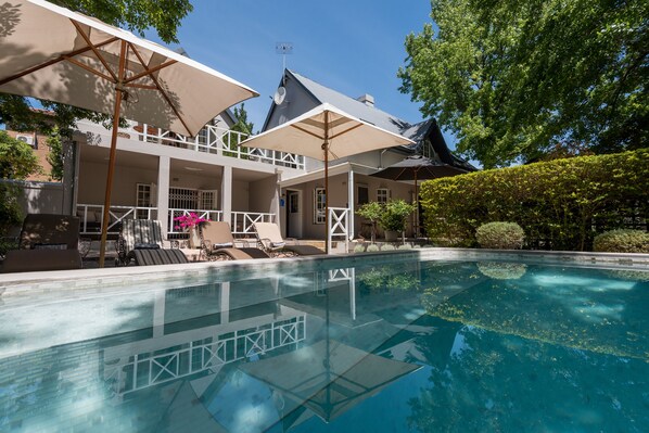 Outdoor pool, a waterfall pool, pool umbrellas, pool loungers