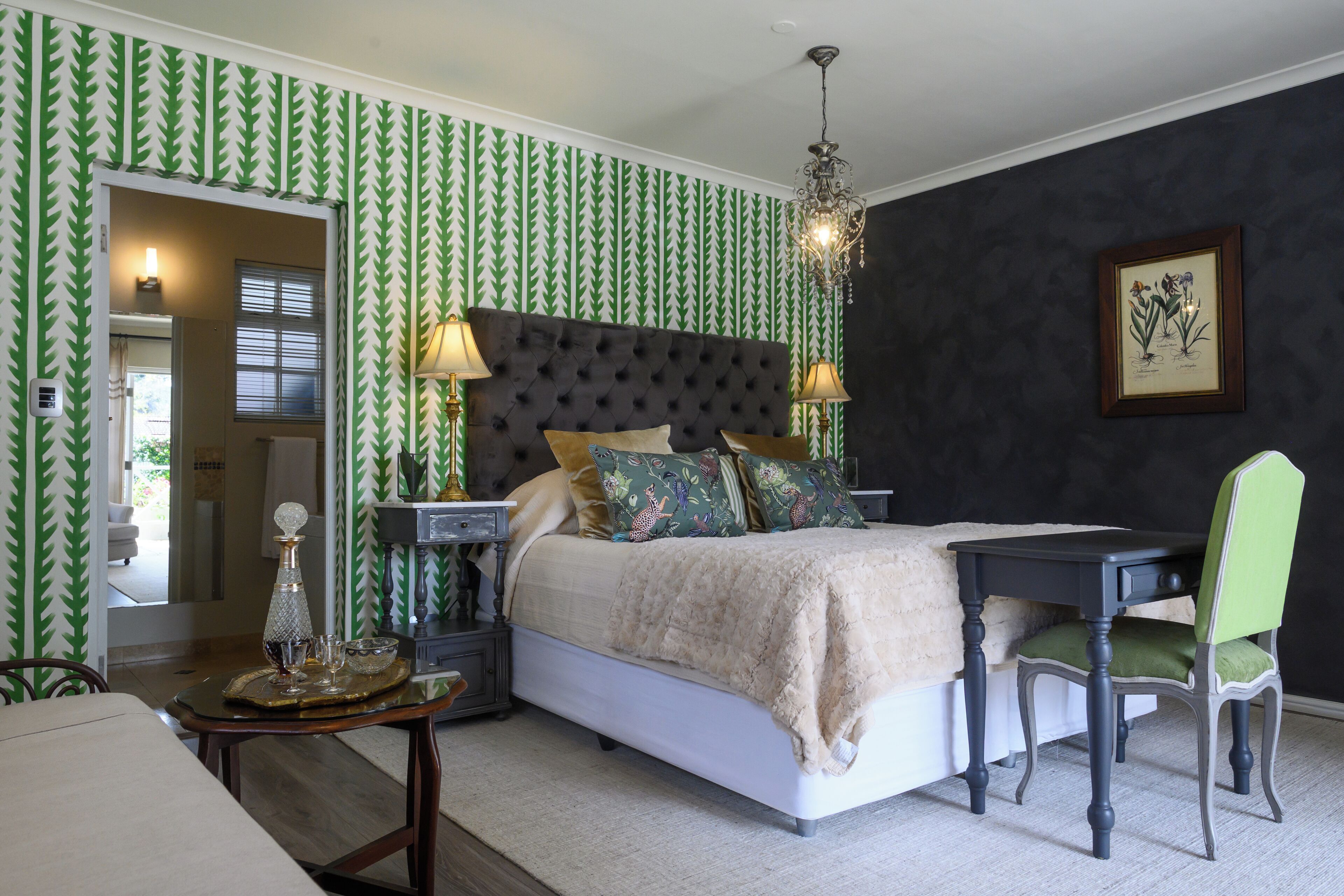 A bedroom with a bed, bedside tables, a desk, and a chair.