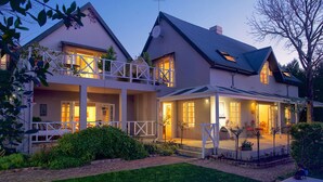A two-story house with a balcony, a swimming pool, and a well-maintained garden. - Baruch Guest House on Rhodes Noord (Stellenbosch)