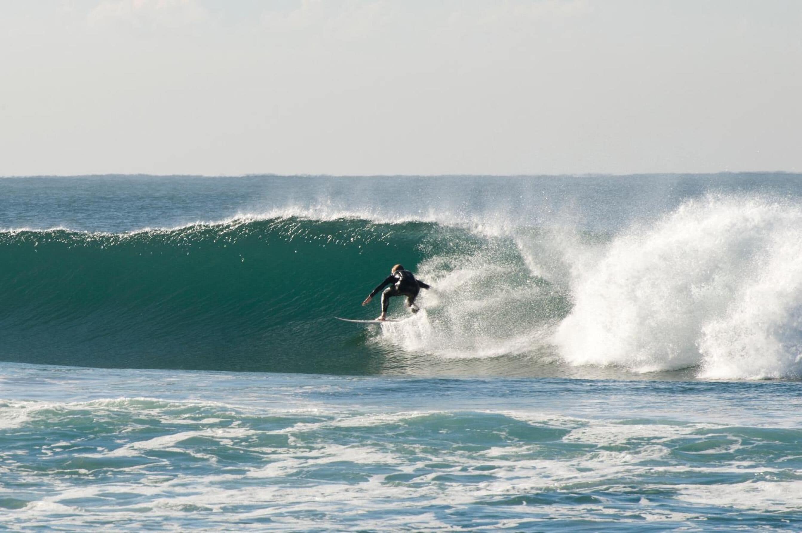 Um surfista deslizando sobre uma onda grande no oceano.