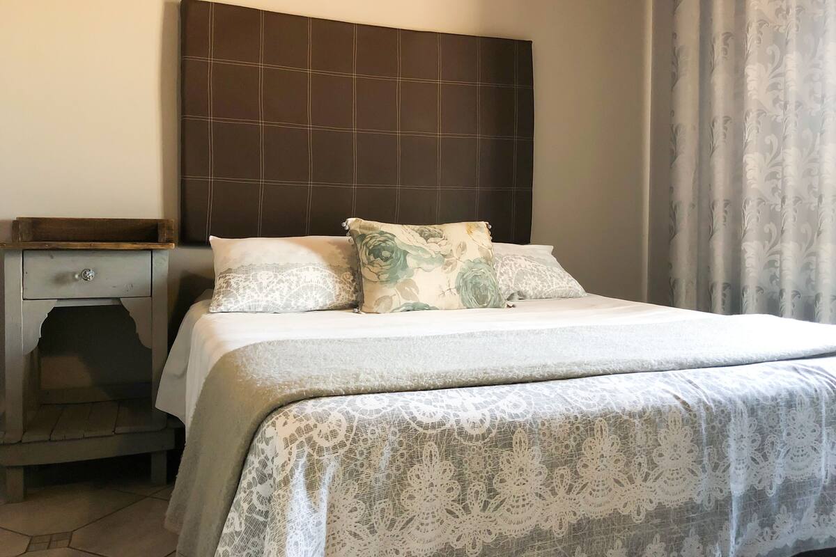 Une chambre à coucher avec un lit, une table de chevet et une tête de lit.