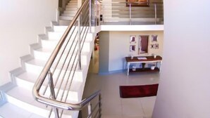 Una escalera moderna con barandillas metálicas que sube a un segundo piso.