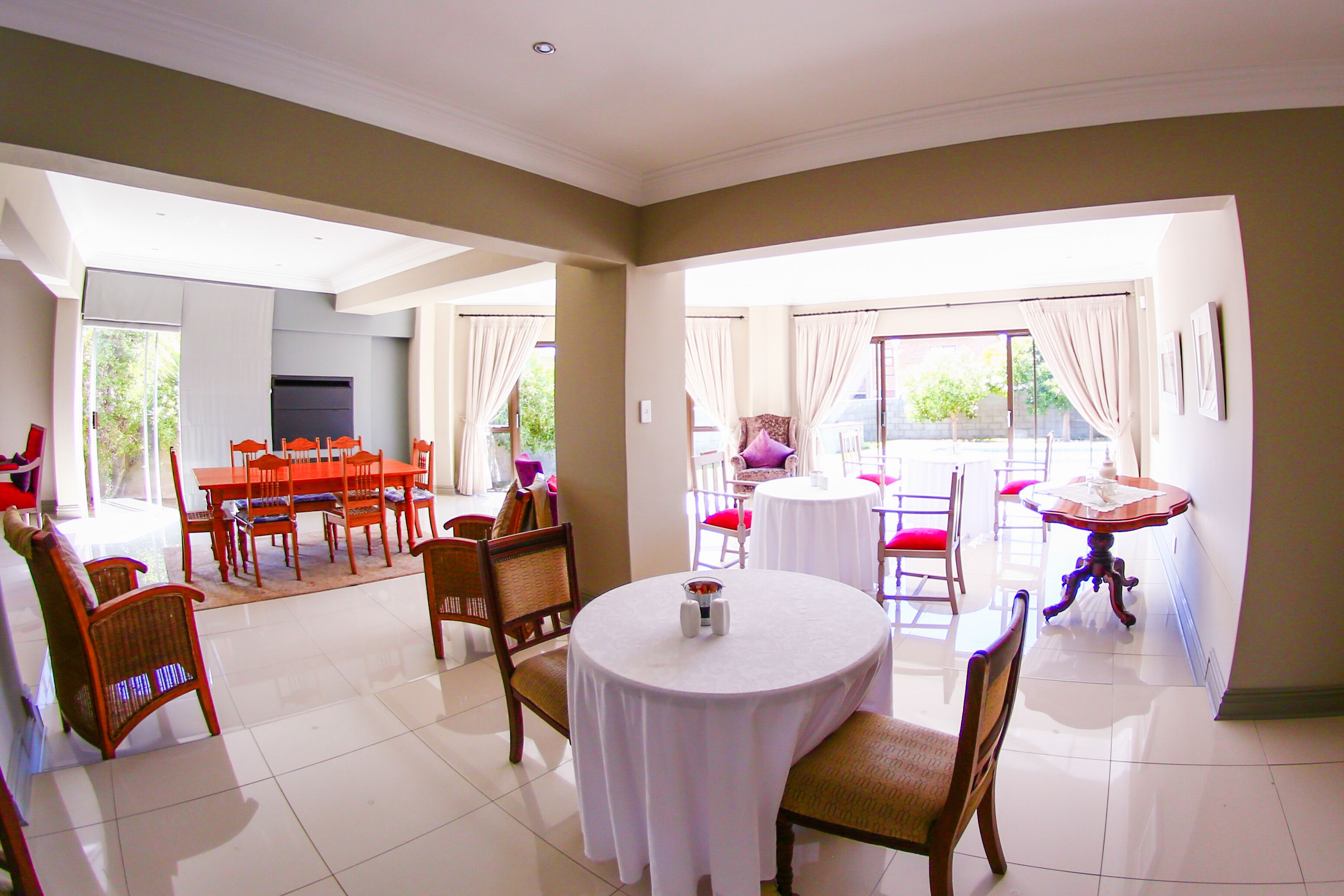 A dining area with a round table, chairs, and a view of the outdoors.