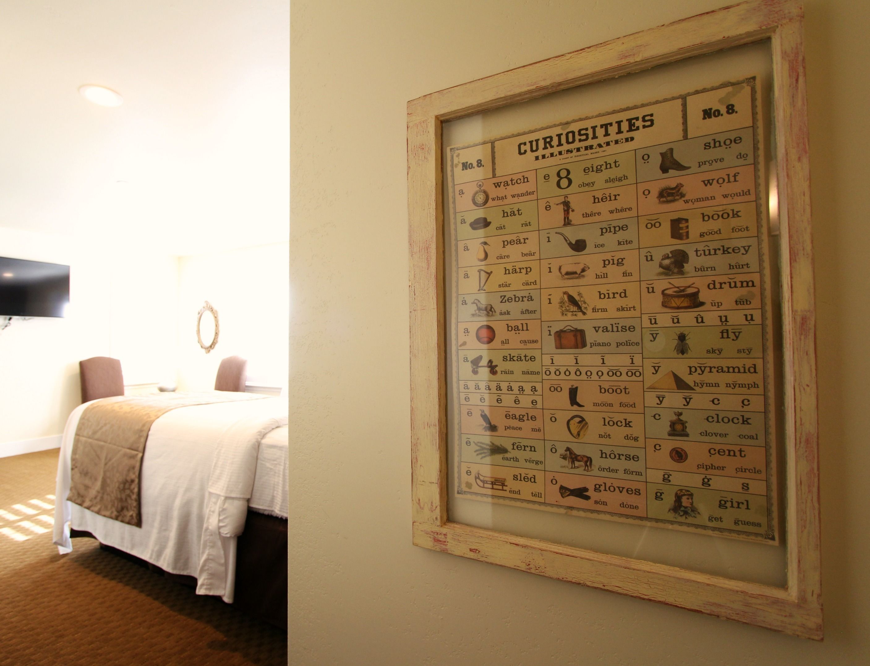 Ein gerahmtes Worträtsel mit dem Titel „Curiosities“ an einer Hotelzimmerwand.