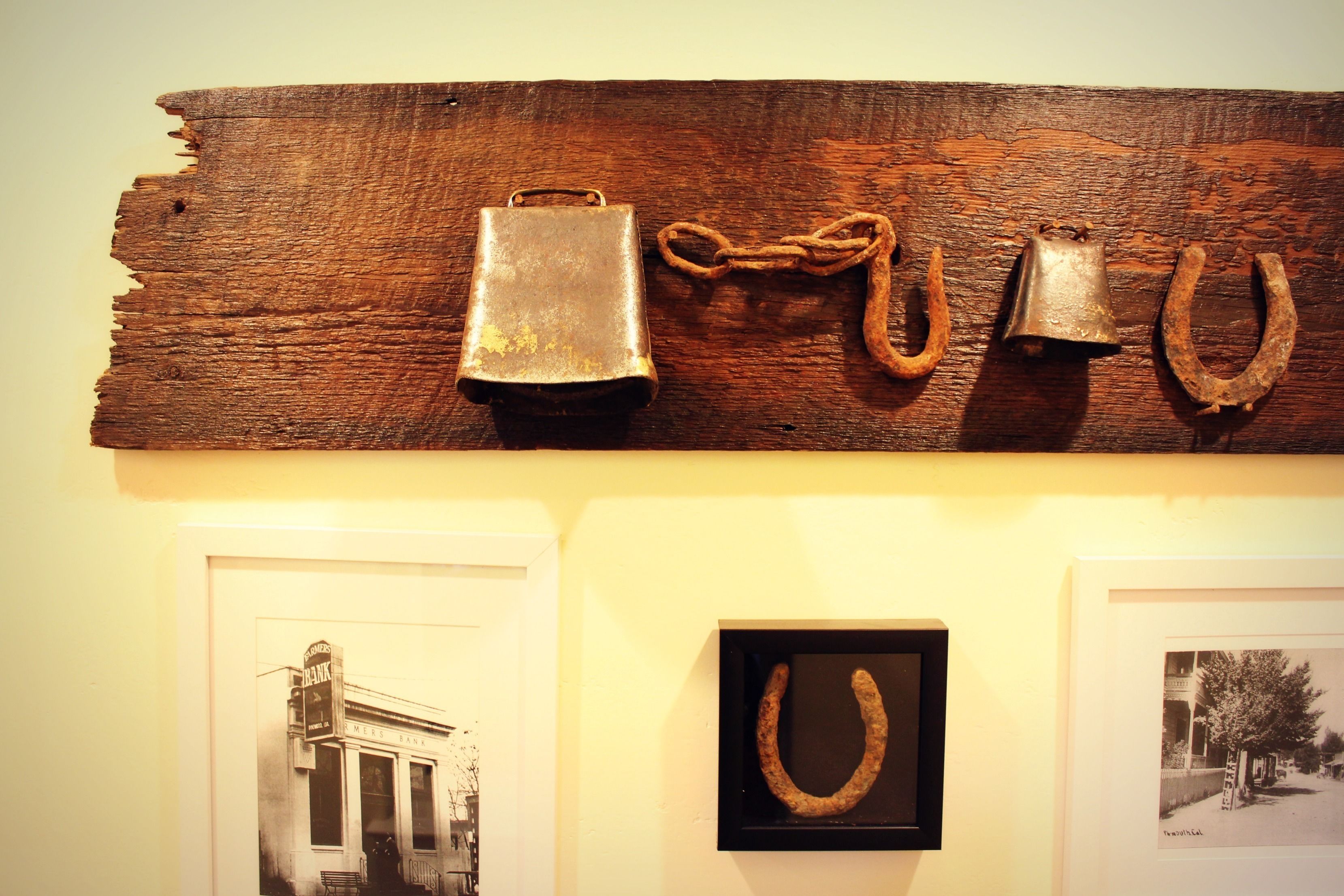 A rustic wooden wall with various metal objects and framed photographs.