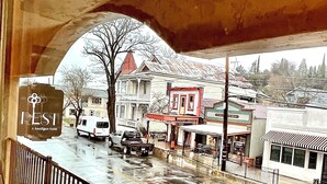 Une vue depuis un balcon donnant sur une rue bordée d’immeubles, dont une bibliothèque et un hôtel.