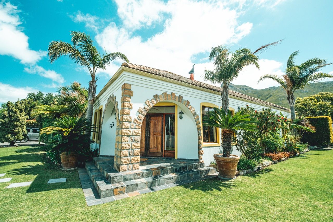 A single-story house with a stone facade, a wooden door, and a number '33' on the front.