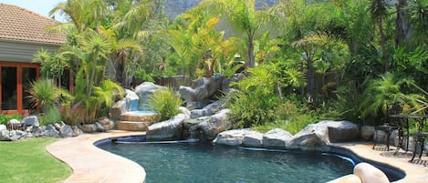 Una piscina al aire libre, sillones reclinables de piscina