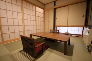 Een traditionele Japanse kamer met tatami vloerbedekking, een lage houten tafel en schuifdeuren van shoji.