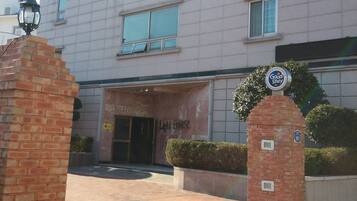 A hotel entrance with a brick pillar, a sign indicating room number 101, and a "Light House" sign above the door.