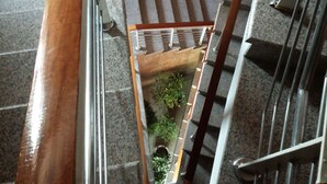 Una escalera interior de varios niveles con barandillas de metal y pasamanos de madera.