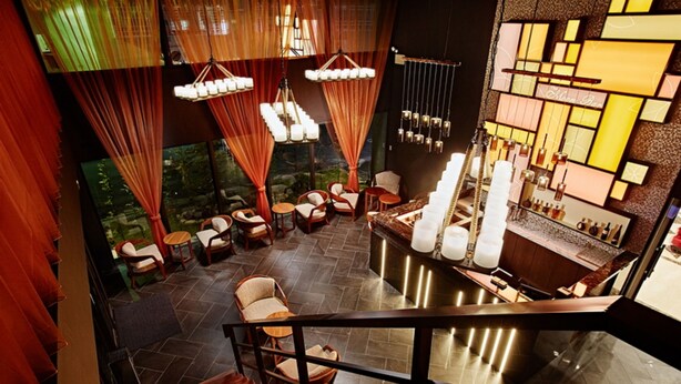 A modern interior with a bar area, seating, and a view of a water feature. - Hotel Sukimi (Tainan)