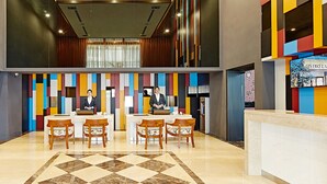 A hotel lobby with a reception desk, a seating area with chairs, and a check-in counter. - Hotel Sukimi (Tainan)