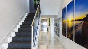 Una escalera con barandilla de vidrio que lleva a una plataforma.