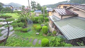 A residential area with traditional Japanese houses, a well-maintained garden with various plants and a stone pathway. - Kajiya Bekkan Ramakkoro Yamenekoyado (Ichinoseki)