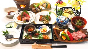 A variety of dishes and food items arranged on a table, including plates of sushi, bowls of soup, and a pot of boiling water. - Kajiya Bekkan Ramakkoro Yamenekoyado (Ichinoseki)