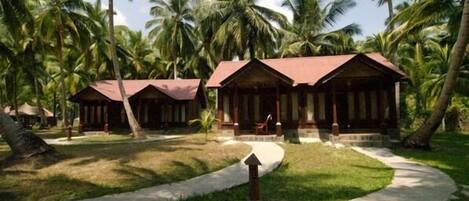 Un resort con diverse cabine in legno circondate da palme.