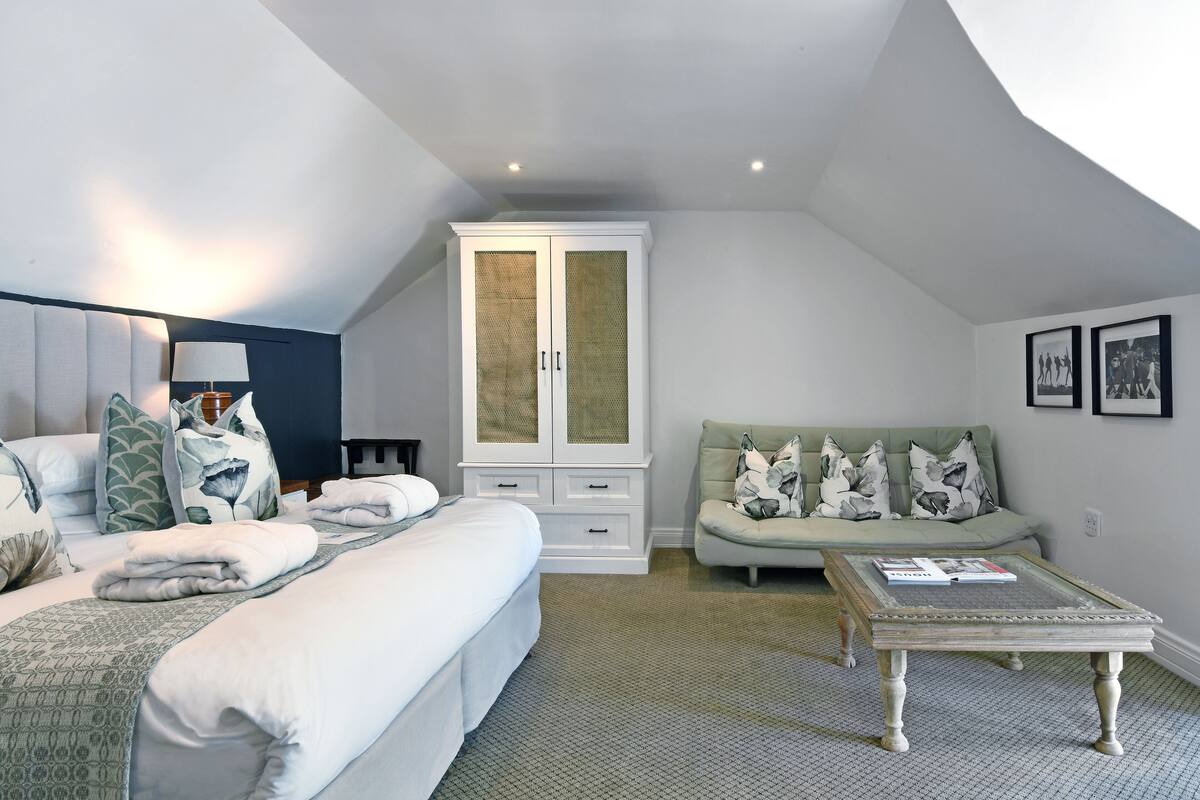 Un dormitorio con una cama, un sofá, un armario y una mesa de centro.