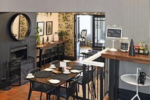 A restaurant with a modern interior, featuring black and white striped walls, a fireplace, and a bar area with a chalkboard sign.